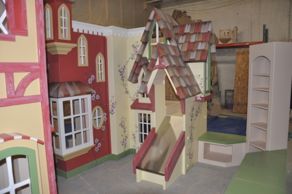 Indoor village playhouse with slide and stairs.