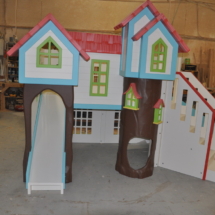 Custom playhouse with treehouse theme, two slides, stairs, and more.