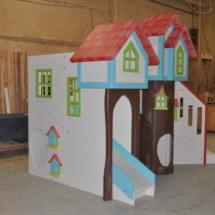 Custom playhouse with treehouse theme and two slides.