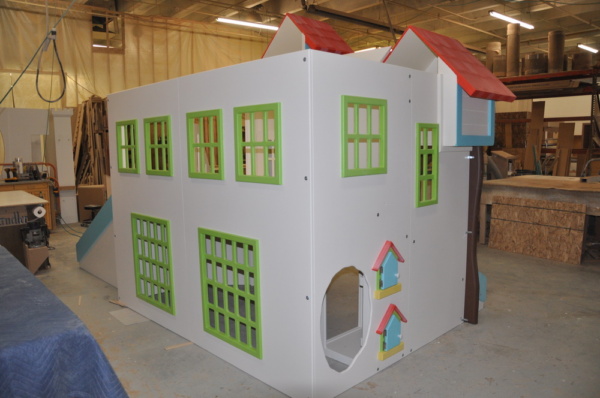 Custom playhouse with green windowsills and functional mailboxes.