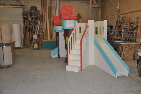 Custom playhouse with slide and stairs.